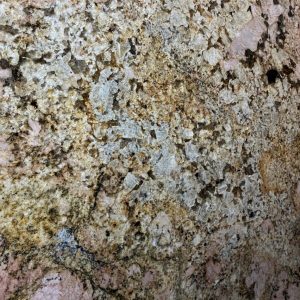 Granite or composite material with cream, tan, and rust-colored speckles and subtle pink undertones