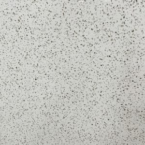 Close-up of white quartz countertop surface with scattered gray and black aggregate speckles