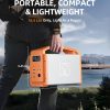 Portable orange and white power station weighing 16.5 lbs with dimensions 11.34 x 9.45 x 6.1 inches being held by a person outdoors near a lake with mountains in background