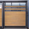 Modern deck gate with horizontal wood slats and patterned metal cutout panels on composite decking