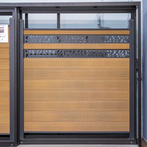 Modern deck gate with horizontal wood slats and patterned metal cutout panels on composite decking