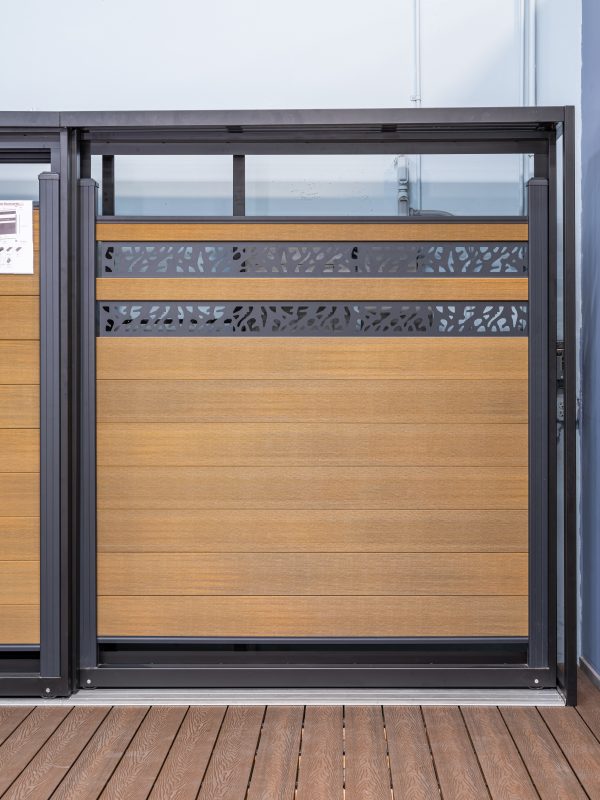 Modern deck gate with horizontal wood slats and patterned metal cutout panels on composite decking