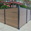 Outdoor privacy screen fence with horizontal wood composite slats and dark metal posts in urban garden setting