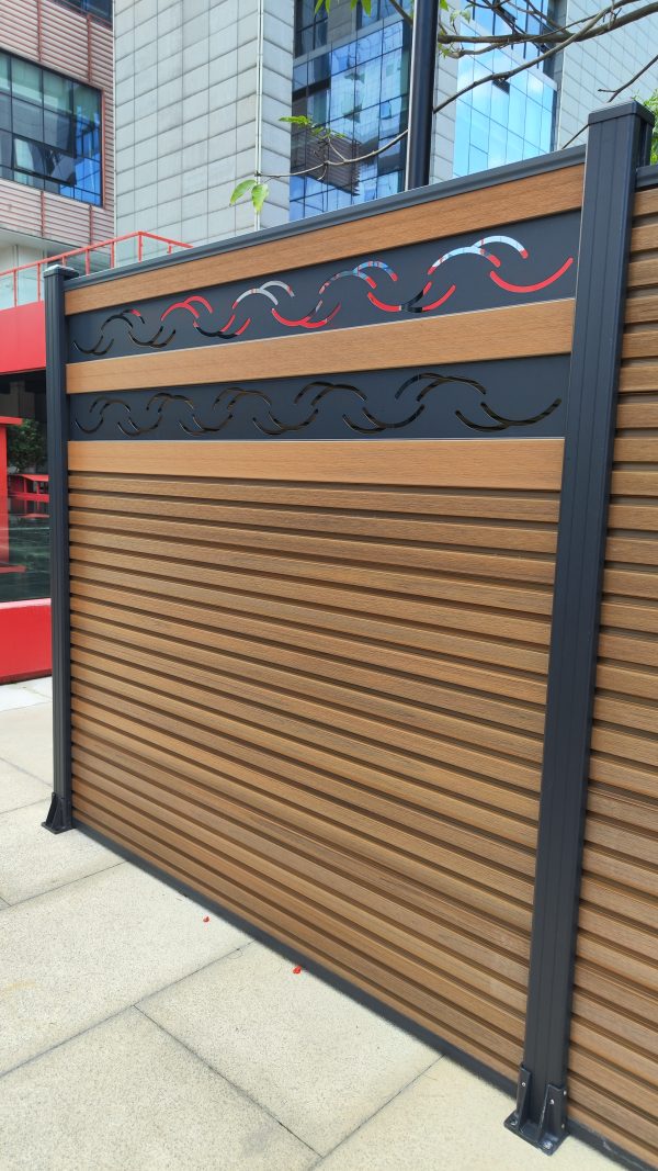 Composite wooden fence with horizontal slats and decorative metal wave inserts in dark and red colors
