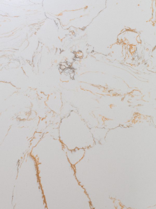 White marble surface with gold and tan veining and natural cracks