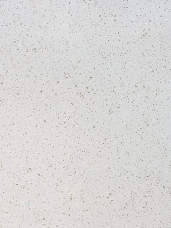 Close-up of white quartz countertop with speckled tan and beige aggregate pattern