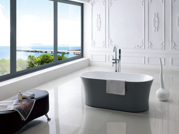 Contemporary bathroom featuring dark gray and white freestanding sofa tub, large windows with ocean view, white decorative wall panels, and modern chrome fixtures