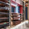 Contemporary closet showroom display with brown pull-out drawers, built-in shelving, illuminated mirror, and organized storage solutions