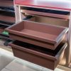 Luxury bedroom closet with extended brown pull-out drawers, wood cabinetry, and organized storage system