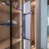Walk-in closet interior showing white frosted glass sliding doors and organized wooden shelves with lighting