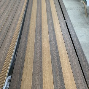 Multiple rows of engineered wood flooring boards in alternating light and dark gray oak finishes