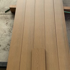 Light oak wood flooring planks laid out on concrete floor showing grain texture and finish