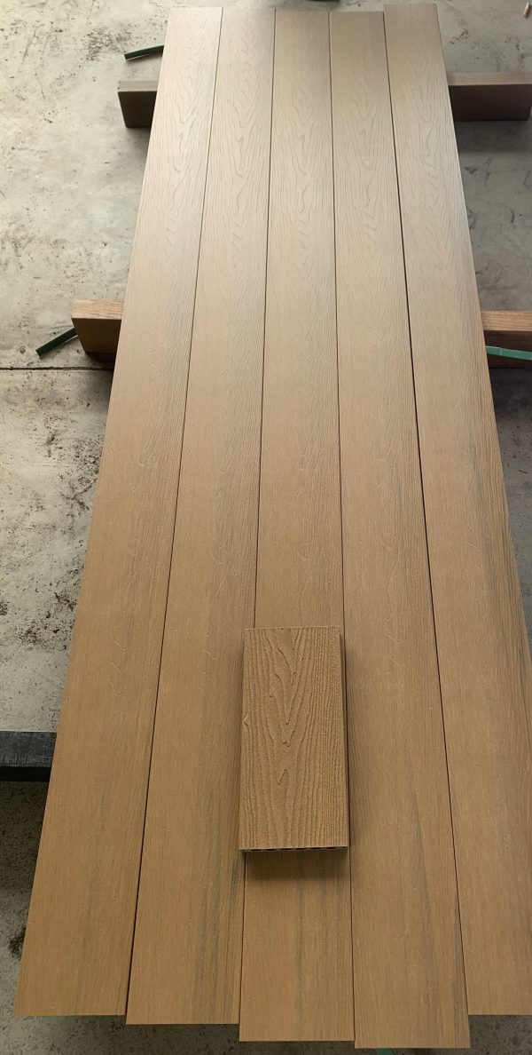 Light oak wood flooring planks laid out on concrete floor showing grain texture and finish