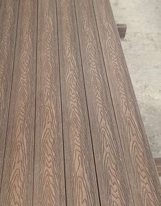 Close-up view of dark gray wood-grain textured flooring planks arranged in parallel rows