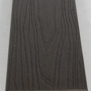 Close-up of dark gray wood grain textured flooring sample with interlocking edge profile