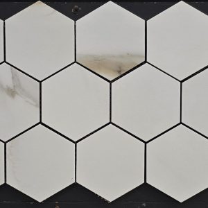 White marble hexagon tiles with subtle gray veining in honeycomb arrangement with dark grout lines