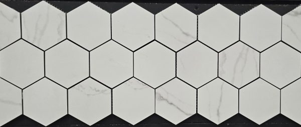 White hexagonal marble mosaic tiles with gray veining arranged in honeycomb pattern with black grout