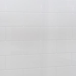 Angled view of white subway tile backsplash with subtle grout lines in staggered brick layout