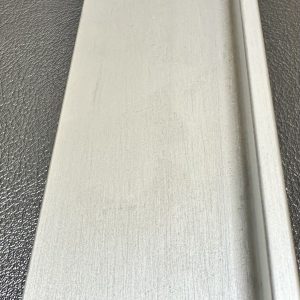 White wooden cabinet door or drawer front with textured surface and edge detail