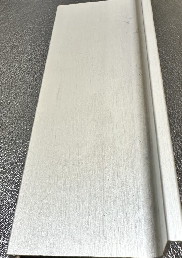 White wooden cabinet door or drawer front with textured surface and edge detail