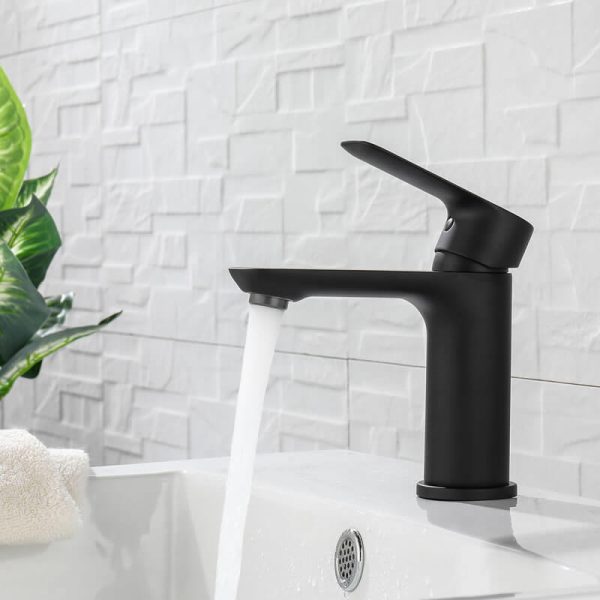 Black modern bathroom sink faucet with single lever handle and curved spout installed on white sink with tile backsplash