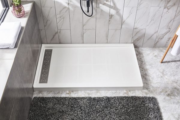 Modern bathroom shower area with marble-look wall tiles and white linear drain pan with dark mat