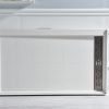 White modern microwave with dark gray vented side panel on gray countertop