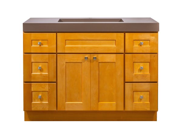 Golden oak bathroom vanity cabinet with brown countertop, featuring central sink area, two-door cabinet base, and six drawers with chrome handles