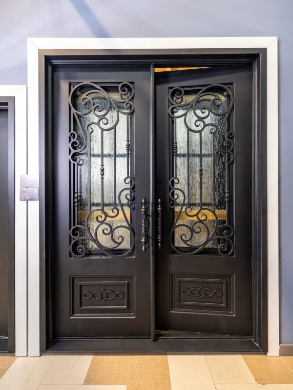 Black double doors with ornate wrought iron scrollwork and decorative glass panels featuring geometric patterns and gold accents