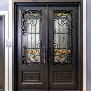Ornate black double entry doors with decorative wrought iron scrollwork and glass panels in white frame