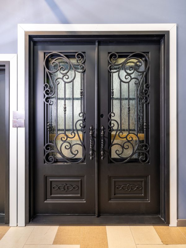 Ornate black double entry doors with decorative wrought iron scrollwork and glass panels in white frame