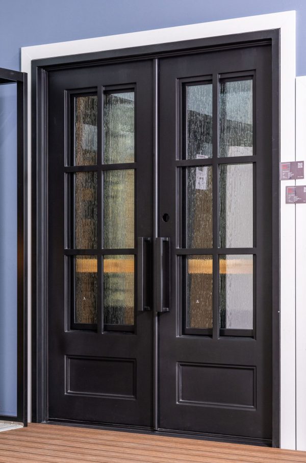 Black double doors with 6-pane grid windows showing weathered wood and stone textures with warm orange and gold tones