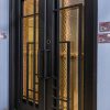 Black double glass doors with geometric grid pattern and gold-tinted glass panels in modern entryway