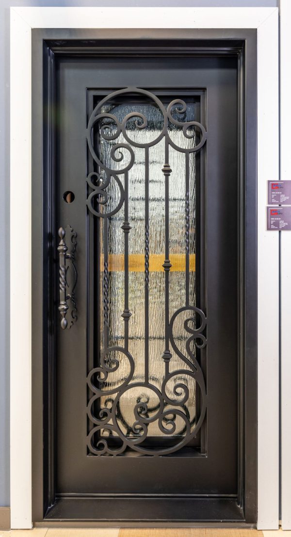 Black wrought iron decorative entry door with ornate scrollwork and weathered wood insert