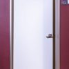 White interior door with silver frame standing open showing wooden interior space