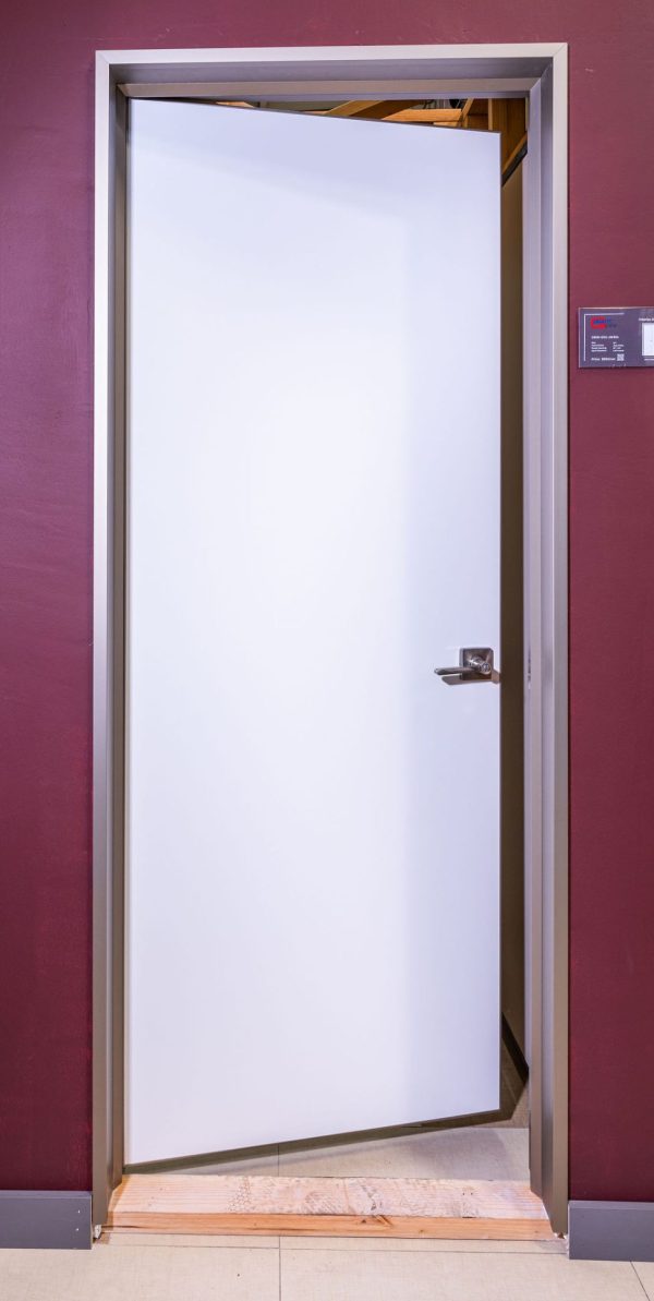 White interior door with silver frame standing open showing wooden interior space