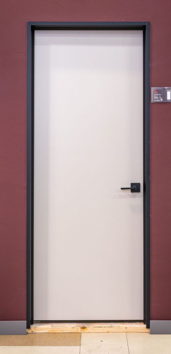 Contemporary light gray interior door with minimalist black hardware and dark frame