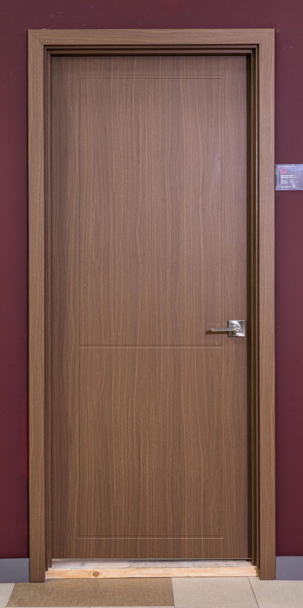 Closed wooden interior door with walnut finish and rectangular panel detail against burgundy wall