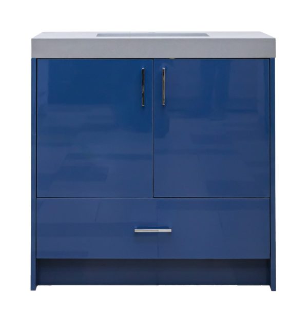 Modern navy blue high-gloss bathroom vanity with gray concrete countertop, two cabinet doors with brass handles, and one lower drawer