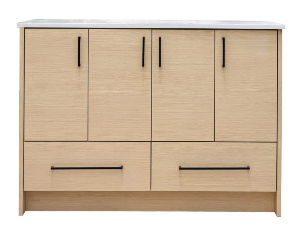 Light natural oak wood bathroom vanity with four upper cabinet doors and two lower drawers, featuring black handles and a white marble countertop with integrated sink