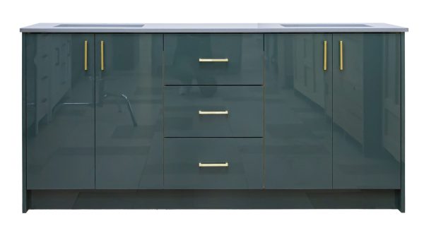 Dark teal green vanity cabinet with dual sinks, three center drawers with brass handles, and two side cabinet doors with brass pulls