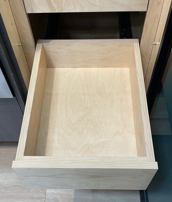 Empty wooden drawer with light wood finish and plywood construction, viewed from above