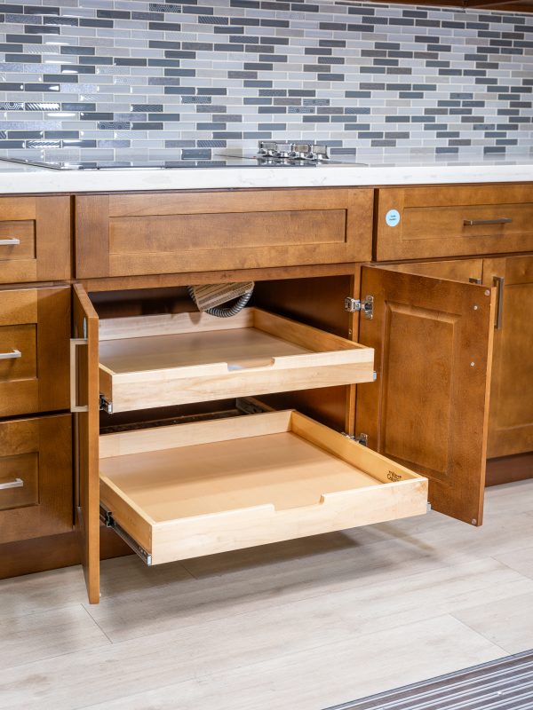 Kitchen cabinet with two wooden pull-out drawers partially and fully extended, showing storage capacity and drawer slides