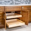 Wooden kitchen cabinet with two pull-out drawers extended showing light wood interior storage