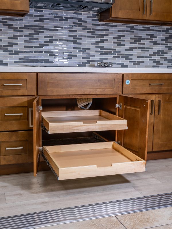 Pull-out wooden drawer organizer in kitchen cabinet with two deep drawers extended, showing natural light wood construction and metal slide hardware