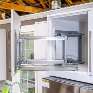 Modern kitchen cabinet with pull-out wire storage shelves and stainless steel appliances