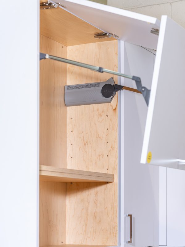 Interior of kitchen cabinet with wooden shelving and mounted paper towel holder on door
