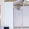 White kitchen cabinet with door open displaying adjustable shelf supports and hinges