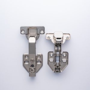 Two metal cabinet hinges with soft-close mechanisms displayed side by side on white background