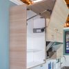Two wooden cabinet doors open showing white interior shelves and 'Exc-Lift System Electric' hardware mechanism mounted inside